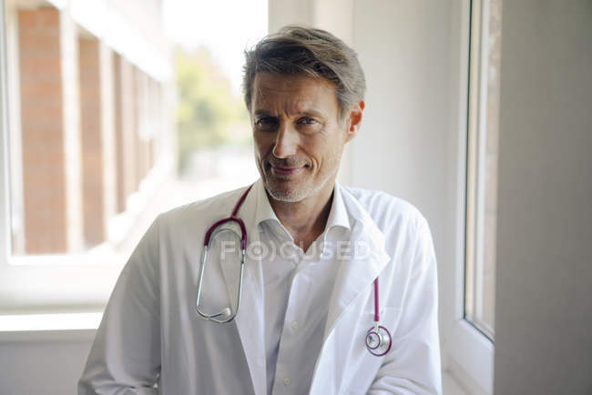 Médico de pé no hospital com estetoscópio ao redor do pescoço, retrato — Fotografia de Stock