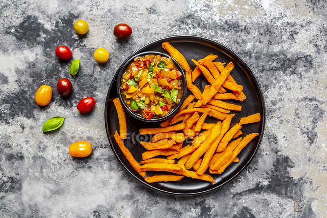 Hausgemachte Süßkartoffelfrites und Schüssel mit Tomaten-Basilikum-Dip — Stockfoto