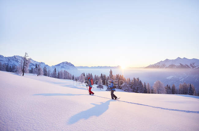 Austria, Tyrol, snowshoe hikers at sunrise — Stock Photo