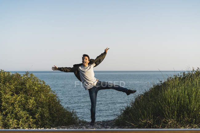 España, joven saltando en el aire en la playa - foto de stock