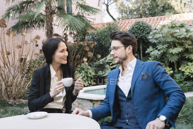 Élégant couple parlant dans un café de jardin — Photo de stock