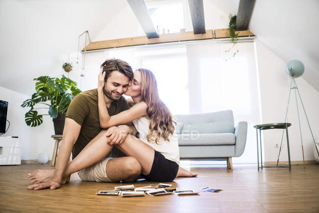 Счастливая пара сидит дома на полу и смотрит на ультразвуковые снимки — стоковое фото
