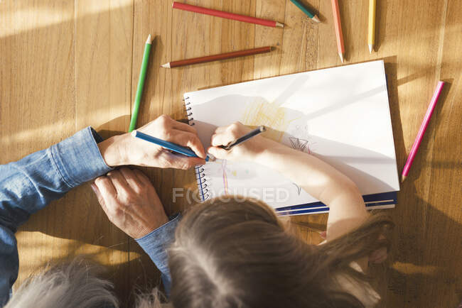 Abuela y nieta haciendo un dibujo juntas - foto de stock