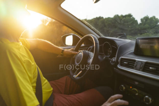 Uomo alla guida di una macchina durante il tramonto — Foto stock