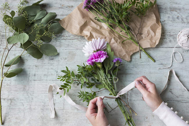 Связывающий букет цветов женской руки — стоковое фото