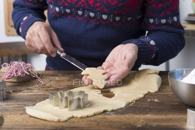 Man Preparing Christmas gingerbread cookies on wooden table — Stock Photo