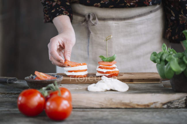 Woman's hands preparing Caprese Salad — Stock Photo