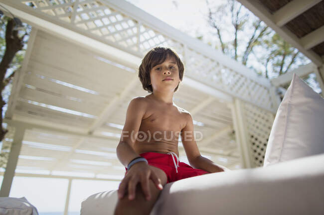 Retrato de um menino sério descansando no salão na praia — Fotografia de Stock