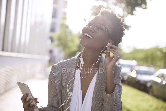 Портрет щасливого ділової жінки за допомогою смартфона і навушники — стокове фото