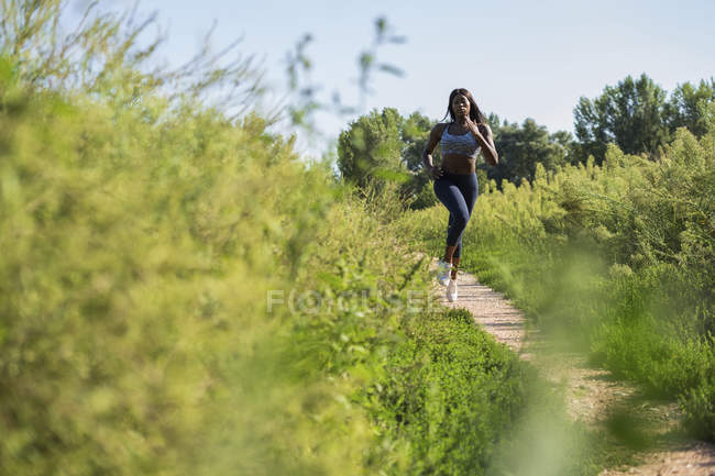 Молодой спортсмен бегает на зеленом поле — стоковое фото