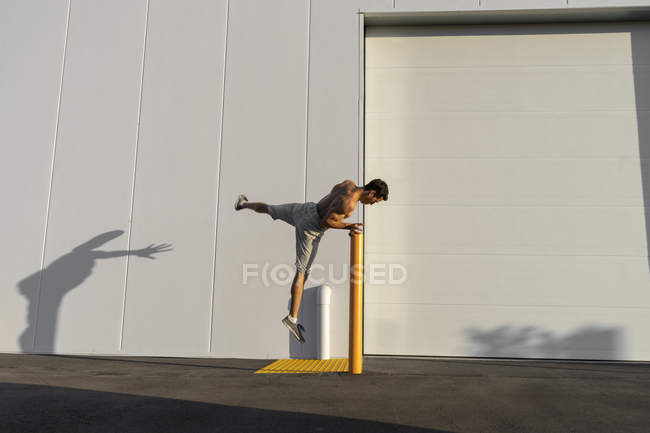 Acrobat training on pole — Stock Photo