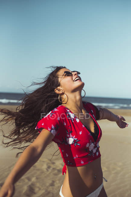 Adolescente divirtiéndose en la playa de arena - foto de stock