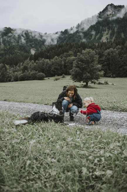 Austria, Vorarlberg, Mellau, mamma e bambino con cane in gita in montagna — Foto stock