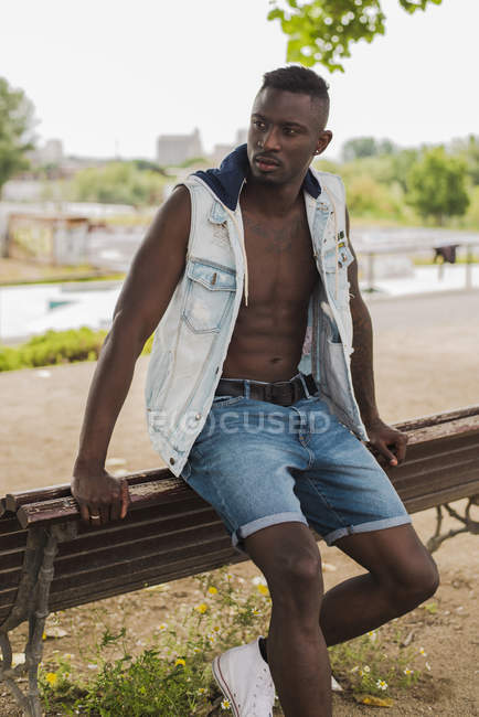 Giovane uomo appoggiato sulla panchina — Foto stock