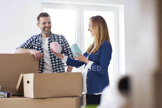 Couple moving into new flat packing cardboard boxes — Stock Photo