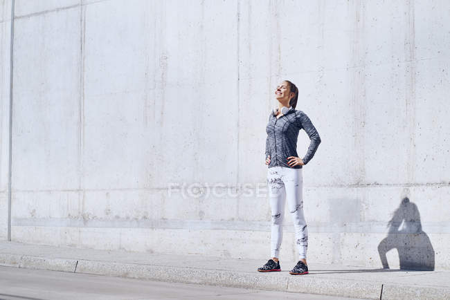 Corredor femenino disfrutando de un día soleado durante el entrenamiento urbano - foto de stock