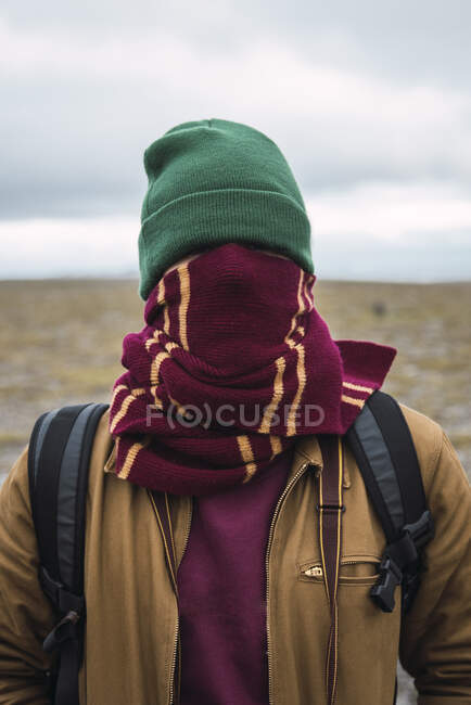 Giovane con cappello e sciarpa di lana, avvolto intorno al viso — Foto stock