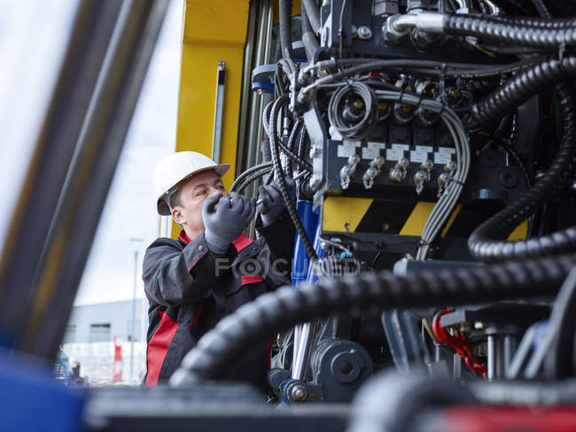 Worker fixing hose line with screw wrench — Stock Photo