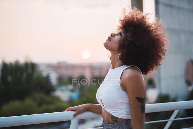 Ritratto di giovane donna in terrazza alla sera crepuscolo guardando in alto — Foto stock