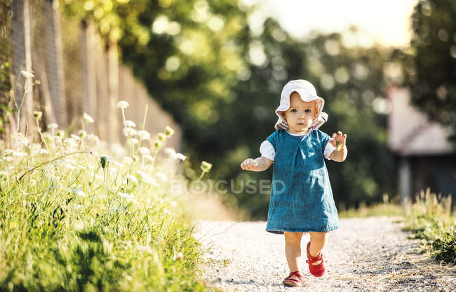 Portrait of baby girl walking outddors in summer — Stock Photo