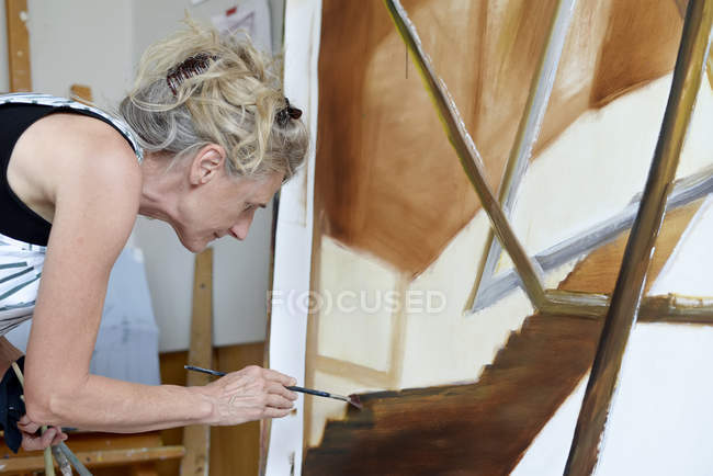 Peintre féminine dans son atelier, peignant un tableau — Photo de stock
