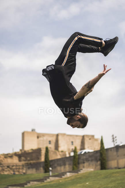 Espanha, Lleida, homem tatuado fazendo parkour em um parque — Fotografia de Stock