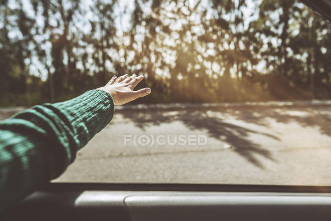 Hand of a woman leaning out of car window — Stock Photo