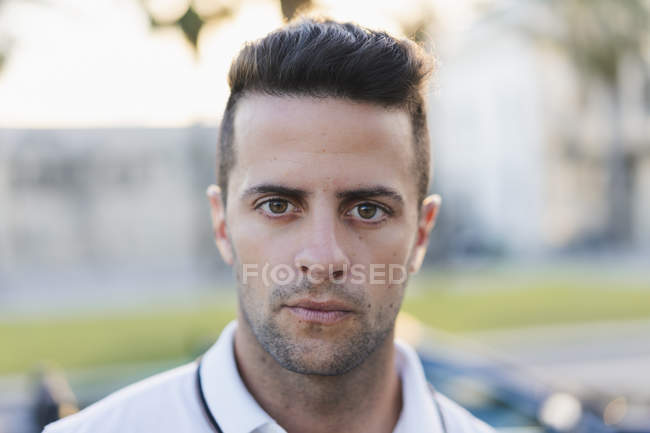 Portrait of serious young man on blurred background of city — Stock Photo