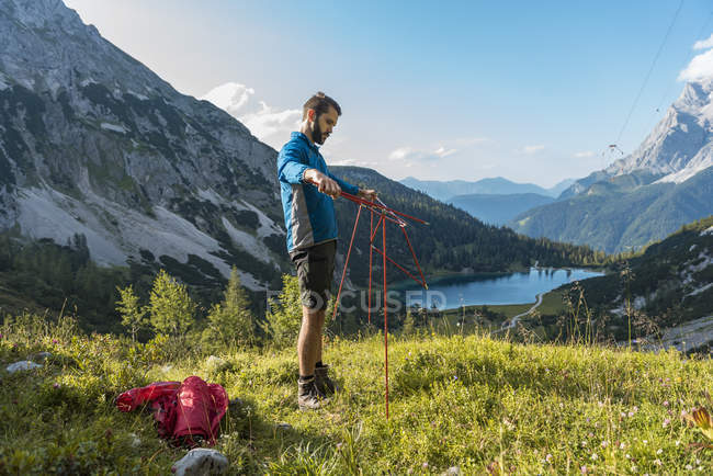 Austria, Tirolo, Escursionista allestimento tenda in montagna sul lago di Seebensee — Foto stock