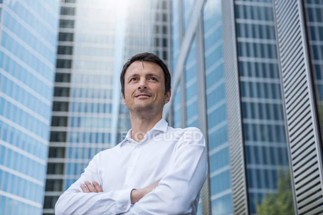 Portrait of confident businessman in front of skyscraper — Stock Photo
