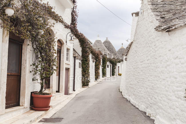 Italia, Apulia, Alberobello, vista al callejón con Trulli típico - foto de stock