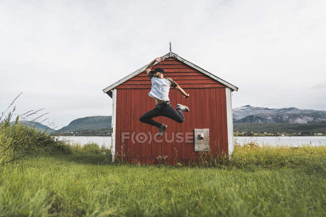 Young man jumping in front of red barn in Norway — funny, positive - Stock Photo | #268653664 Young man jumping in front of red barn in Norway — funny, positive - Stock Photo | #268653664