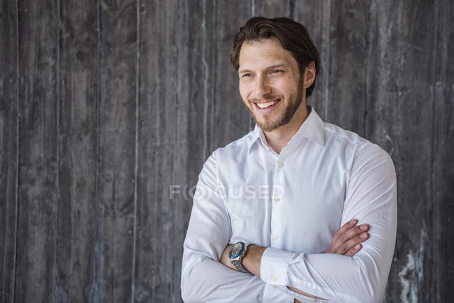 Retrato del hombre de negocios sonriente en la pared de hormigón - foto de stock
