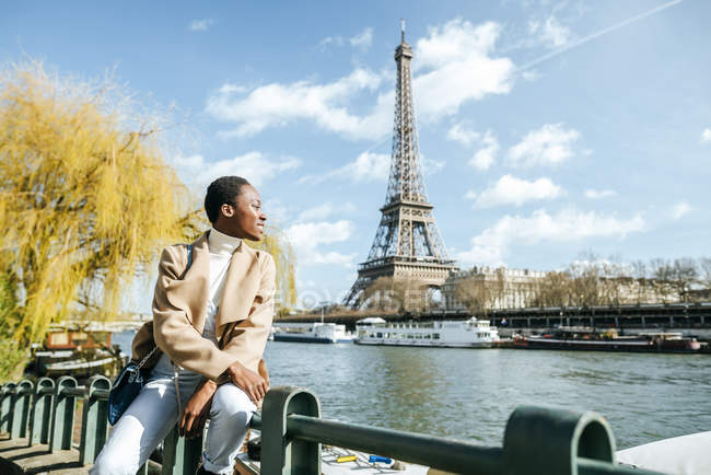 França, Paris, Mulher sorridente no rio Sena com Torre Eiffel no fundo — Fotografia de Stock