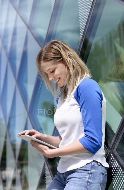 Jeune femme blonde utilisant une tablette — Photo de stock