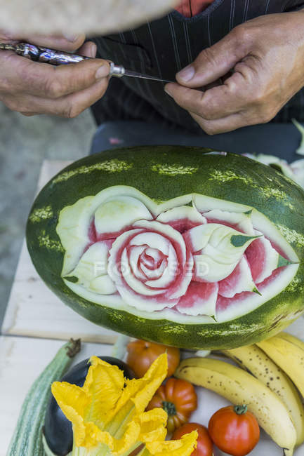 Close-up de homem decorando uma melancia com ferramenta de escultura — Fotografia de Stock