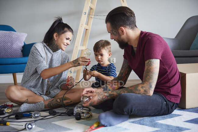 Família moderna feliz que decora a casa para o Natal — Fotografia de Stock