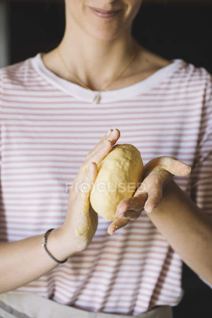 Жінка замішувати макарони тісто в руках — стокове фото