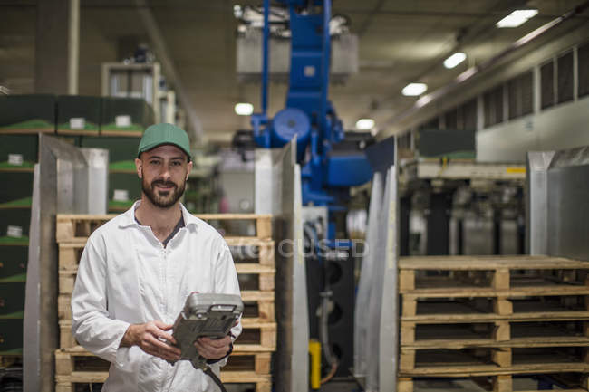 Worker holding control panel in factory — Stock Photo