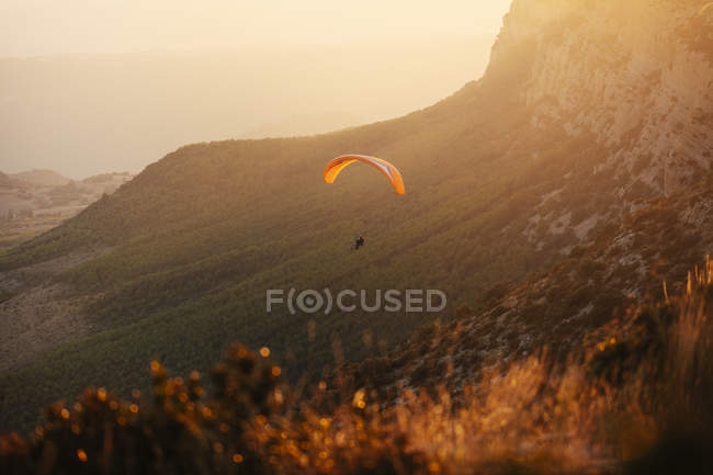 Espagne, Silhouette de parapente s'élevant au-dessus des montagnes au coucher du soleil — Photo de stock