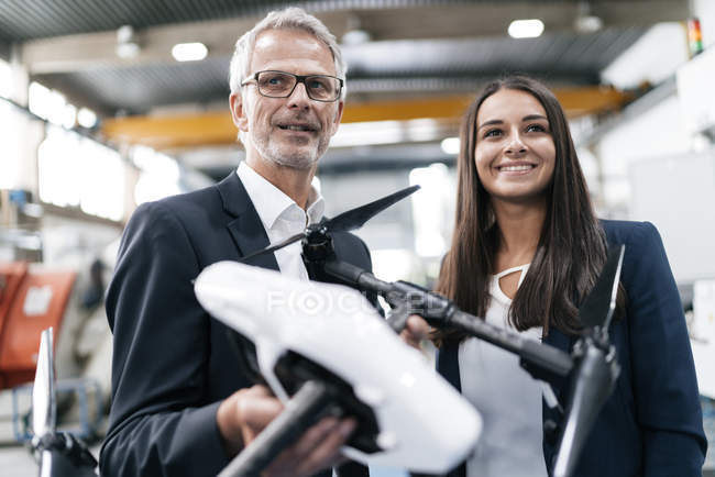 Homme d'affaires et femme d'affaires dans une entreprise de haute technologie, discutant de la production de drones — Photo de stock