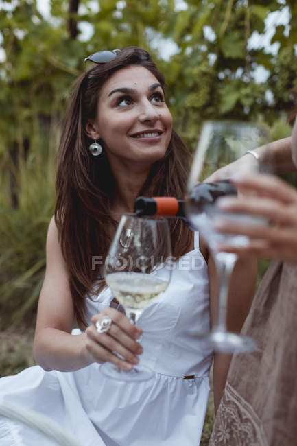 Donna versando vino in vetro su un picnic in natura — Foto stock