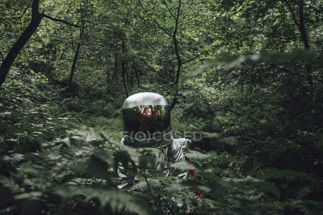 Homme de l'espace explorant la nature, debout dans la forêt verte — Photo de stock