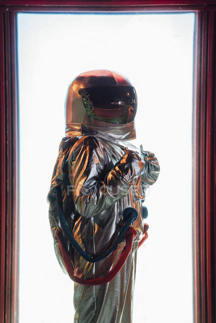 Вид сбоку космонавта, стоящего у иллюминированной коробки — стоковое фото