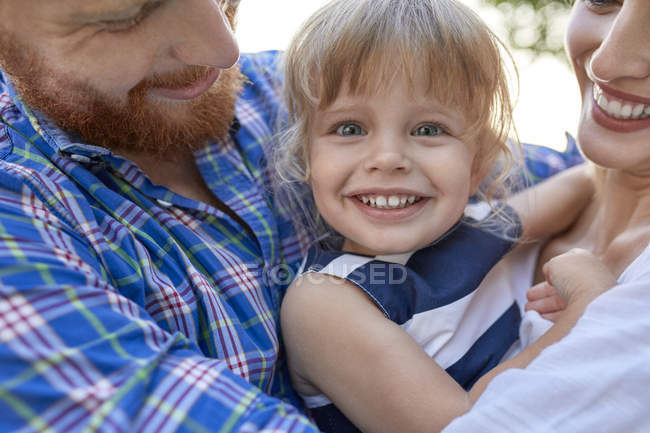Felice genitori abbracciare sua figlia all'aperto — Foto stock
