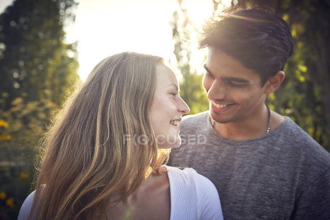 Счастливая молодая пара флиртует в парке летом — стоковое фото
