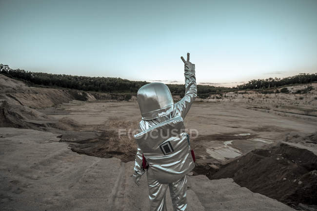 Raumfahrer macht Friedenszeichen auf namenlosem Planeten — Stockfoto