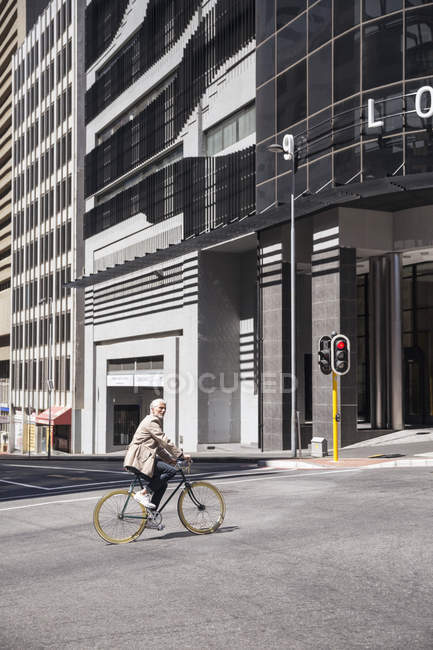 Elegante homem maduro andar de bicicleta na cidade — Fotografia de Stock
