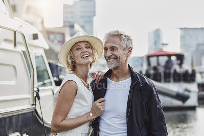 Man and young woman with age difference laughing next to yacht — Stock Photo