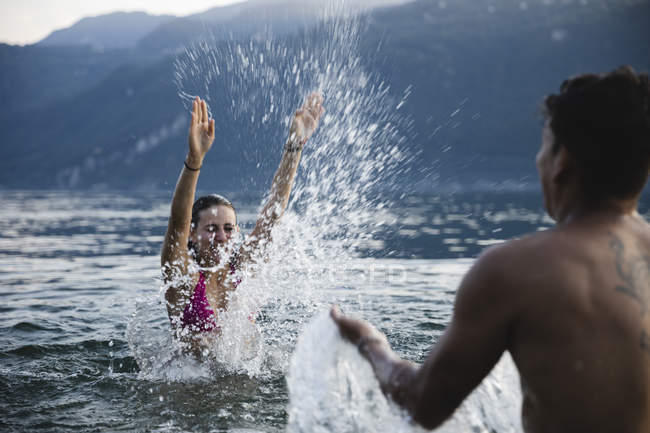 Glückliches junges Paar spielt in einem See — Stockfoto